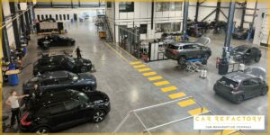 Overhead view of Car Refactory's large-scale vehicle refurbishment workshop with multiple cars in process