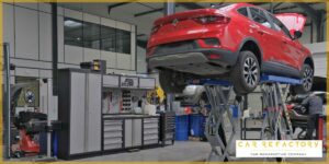 Red Renault vehicle on hydraulic lift during professional refurbishment at Car Refactory's advanced facility
