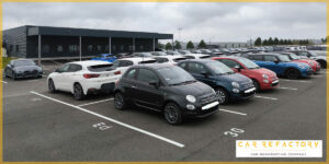 Organized fleet vehicle storage with various car models awaiting professional vehicle refurbishment services